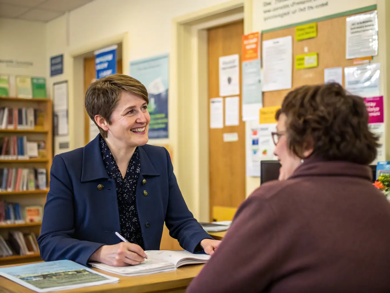 A compassionate case manager sitting with a survivor, reviewing a personalized support plan in a bright, welcoming office. The scene emphasizes trust and collaboration.